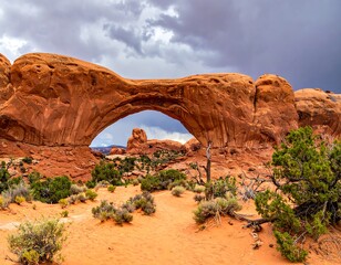 Vast natural arch in a desert landscape under a cloudy sky