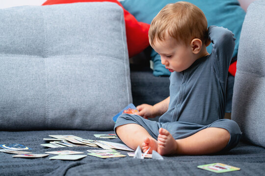 Curious toddler learning with educational picture cards at home.