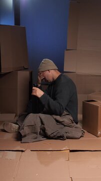 vertical video Homeless man experiencing despair and poverty holding bottle of alcohol