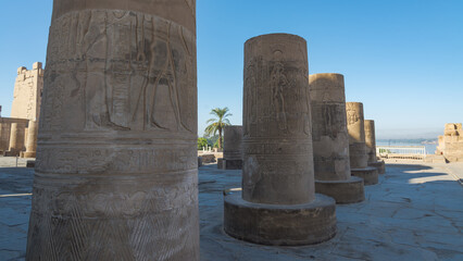 Columns with hieroglyphics at the famous temple of Kom Ombo, close to the river Nile, Egypt. Blue sky on the background.