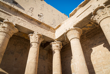 Set of columns with hieroglyphics at the famous temple of Edfu, Egypt, dedicated to the god Horus. Blue sky on the background.