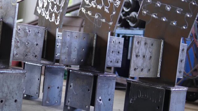 Steel structures, metalwork, and welding. Large steel components in an industrial workshop. Structural steel with welded joints and bolt holes.