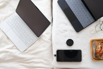 Cozy Workstation Laptops and Smartphone on Bedding for Comfort and Productivity