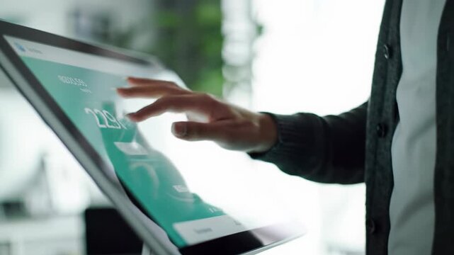 Well-groomed, gender-neutral hand in smart-casual attire fluidly gestures on a sleek digital touchscreen with vibrant gui and updating data, captured in an ecu to ms video with soft lighting in a