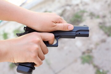 Person hands racking the slide of an airsoft gun.