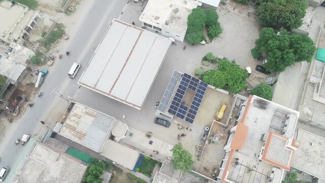 A high-resolution aerial view of a solar power plant with rows of photovoltaic panels and rooftop solar installations capturing sunlight for clean electricity generation, symbolizing green energy and 