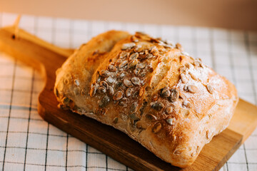Freshly baked bread with crunchy watermelon seeds on a rustic wooden board