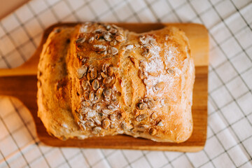 Freshly baked bread sprinkled with watermelon seeds on a wooden board