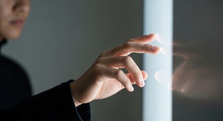 Person interacting with a bright vertical glowing screen interface.