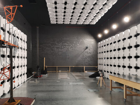 An interior view of a 10-meter EMC anechoic chamber, showcasing the specialized antenna setup used for electromagnetic compatibility testing. The room is lined with pyramidal absorbers for precise RF