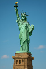 Fototapeta premium Statue of liberty front view against clear blue sky highlighting iconic landmark torch crown and pedestal structure