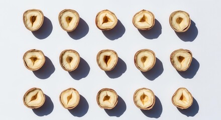 Array Of Halved Hazelnuts Against White Background With Shadows And Artistic Arrangement