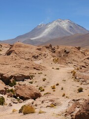Active Volcán Ollagüe in the Bolivian Altiplano desert, with steam vents and arid mountain landscape under clear skies.
