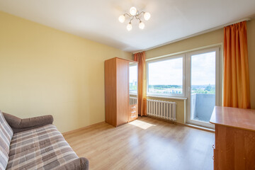 Minimalism Home Bedroom Interior. Closet, Hardwood Floor. Sofa Couch. Heater and Window in Background