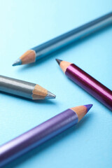 Eye pencils on light blue background, closeup