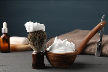 Different barber's tools on grey wooden table, closeup