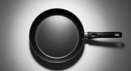 Overhead shot of a black non-stick frying pan with a handle showcasing a sleek modern kitchenware design ready for cooking