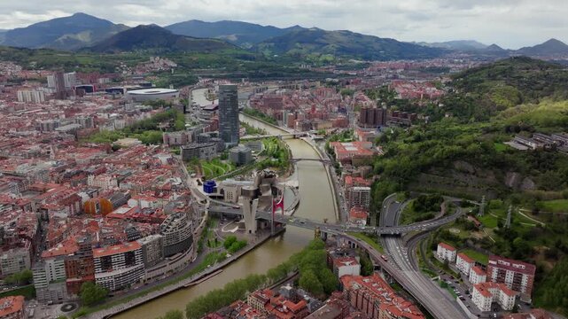 Tripod shot from a unique high-altitude perspective of the city of Bilbao, Guggenheim Museum, Nervion River flowing through urban landscape in Spain
