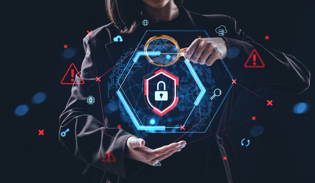 Cybersecurity threat detection concept with holographic lock icon and digital warning symbols held by businesswoman in dark background scene.