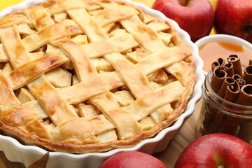 Tasty homemade apple pie and ingredients on table, closeup