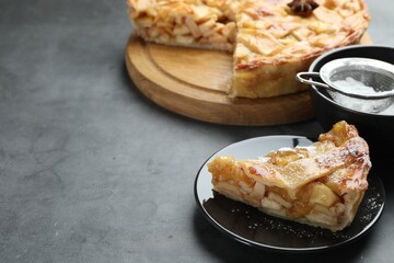 Pieces of delicious homemade apple pie on grey textured table, closeup. Space for text