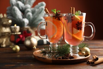 Tasty punch drink, spices and Christmas decor on wooden table, closeup