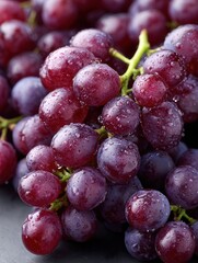 Fototapeta premium A close-up of fresh red and purple grapes covered in water droplets, showcasing their freshness and juiciness, ideal for food-related themes.