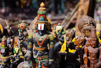 Wooden art, Handmade wooden idol on lord tirupati at surajkund craft fair. Selective focus.