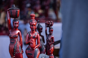 Handmade tribal people of africa souvenir idol from african artist on display at surajkund craft fair for sale. Selective focus.