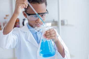 Smile African boy elementary students kids wearing lab coat attention dropping liquid substance into flask glass in laboratory classroom, lifestyle learning education in science class national pupils