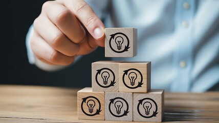 Hand stacking wooden blocks with refresh lightbulb icon, idea generation