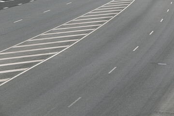 View of a multi-lane road with marking lines. Road background with asphalt and marking lines texture