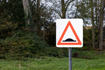 Speed bump warning UK road sign with green background traffic and safety concept