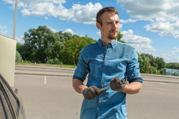 Man in unscrewing lug nuts on car wheel in process of new tire replacement,using wrench outdoor