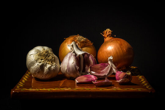 Bodeg&oacute;n de ajos y cebollas con claroscuros, imitaci&oacute;n pintura al estilo de iluminaci&oacute;n de Caravaggio