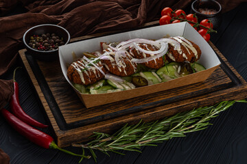 Lunchbox with falafel on a wooden tray