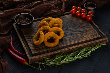 Breaded onion rings on a wooden tray