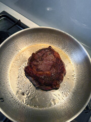 A piece of steak on the frying pan.