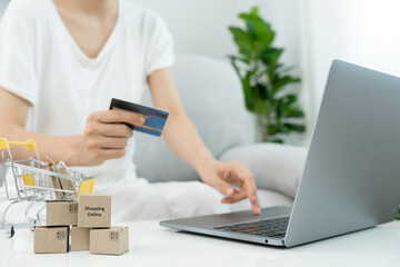 woman using laptop for online shopping at home. Hand holding mobile phone with payment detail page display and credit card, stay home, technology, electronic commerce, internet, market place