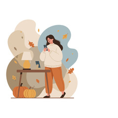 Woman using a smartphone indoors in a cozy autumn setting with warm light and seasonal pumpkin decorations