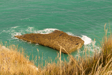 Famous white cliffs of Étretat, Normandy, France, rising above turquoise sea waters. Iconic coastal landscape known for its natural beauty and dramatic rock formations.