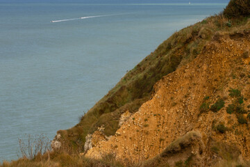 Two motorboats speeding across the calm blue sea near the cliffs of Étretat, Normandy. A dynamic coastal scene blending motion and natural beauty.