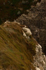 Famous white cliffs of Étretat, Normandy, France, rising above turquoise sea waters. Iconic coastal landscape known for its natural beauty and dramatic rock formations.