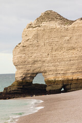 White chalk cliffs and natural arch at Étretat, Normandy, France, overlooking the turquoise sea. Scenic coastal landscape famous for its dramatic beauty and ocean views.