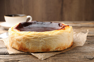 Tasty Basque cheesecake on wooden table, closeup