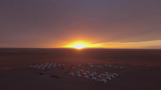 Drone flying over Mongolian ger camp at sunset in the Gobi Desert