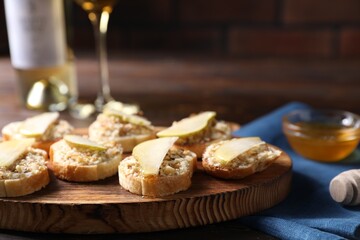Tasty bruschettas with apples, honey and walnuts on wooden table, closeup