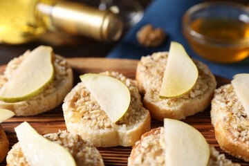 Tasty bruschettas with apples, honey and walnuts on table, closeup