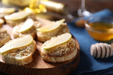 Tasty bruschettas with apples, honey and walnuts on table, closeup