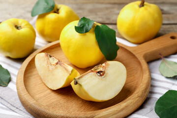 Whole and cut ripe quinces on table, closeup